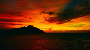 A scintillating sunset over Castaway Island lights up the sky a fiery orange-red, Malolo Island, the Mamanucas, Fiji