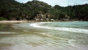 A granite headland framing a shimmering arc of sand on Magnetic Island